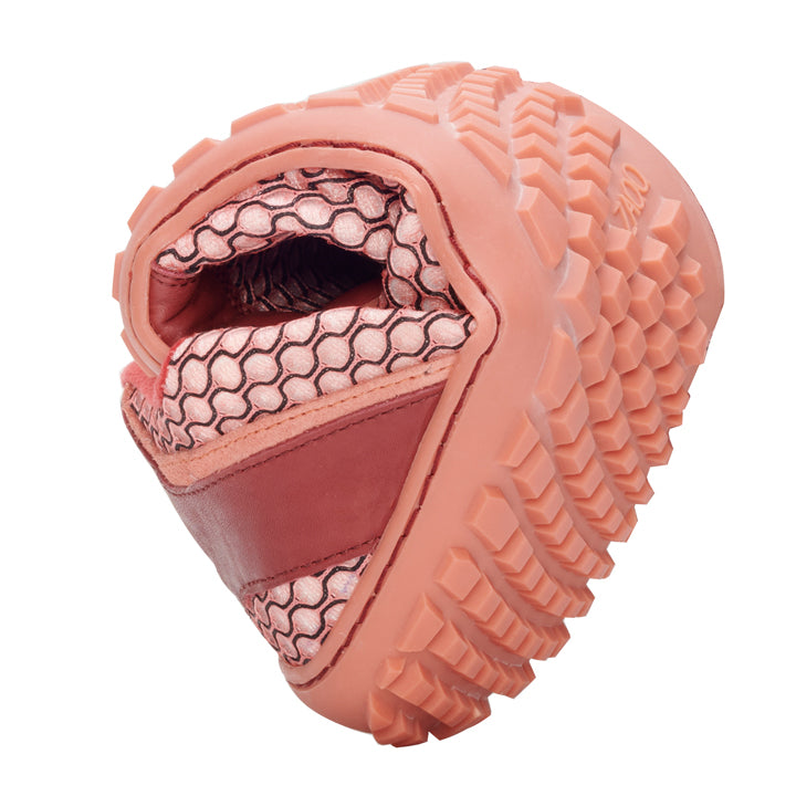 Close-up of an upside down pink and red sneaker. The structured one ZAQQ-Sole and the mesh inner pattern are highlighted and resemble the TOQIO Coral design.
