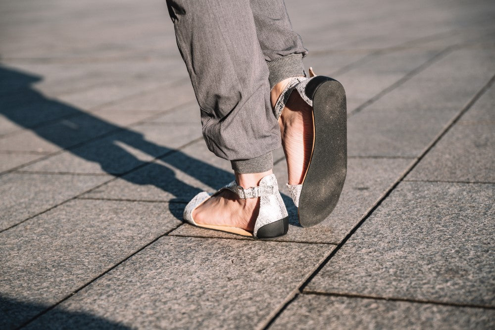 CLIQ Silver sandals from ZAQQ featuring a silver metallic finish, open toe, ankle strap and a rubber sole on a white background.