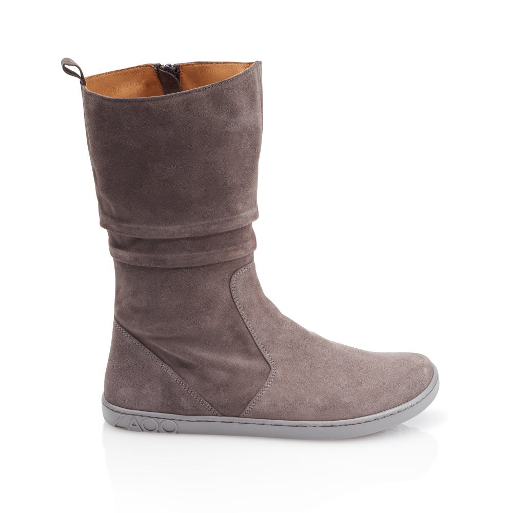The ZAQQ QOM Gray is a gray goat suede mid-calf boot with a side zip closure and flat sole that stands out against a white background.