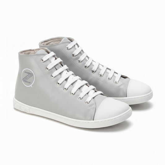 Die stylischen CHUQQS Grey High-Top-Sneaker von ZAQQ zeichnen sich durch ein markantes Z-Logo und eine dezent abgenutzte Sohle aus. Sie sind aus Nappaleder gefertigt, haben weiße Zehenkappen und Schnürsenkel und bieten eine elegante Mischung aus Komfort und Stil.