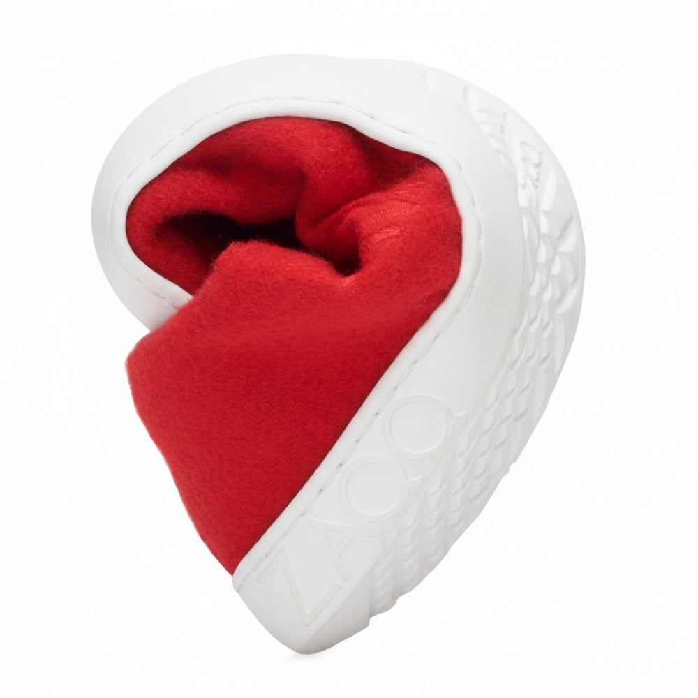 A sculpted gray stone in the shape of an ear with detailed structure folds around a bright red cloth, reminiscent of the LIQE Race sneaker, crafted for the comfort of a barefoot sole. The word ZAQQ is engraved into the surface of the stone.