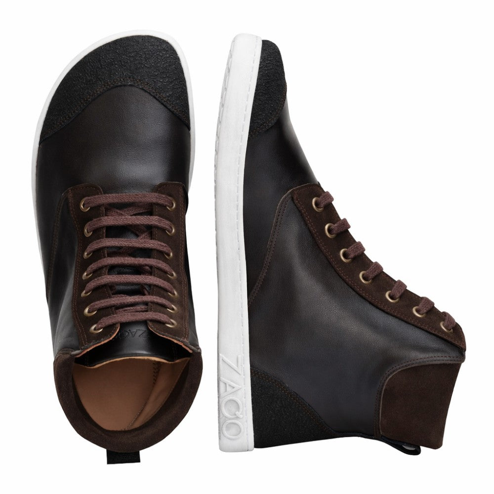 Two dark brown MINSQ mid-cut sneakers from ZAQQ. One sneaker stands upright and features a branded white sole, while the other lies on its side and flaunts a dark brown upper and matching laces.