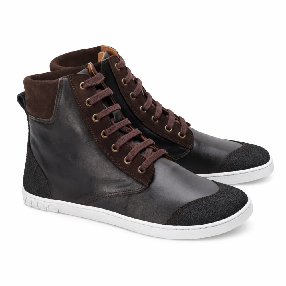 Introducing the MINSQ Dark Brown sneakers from ZAQQ: a stylish pair of dark brown mid-cut sneakers with a white sole, brown laces and a suede collar. These sneakers feature a modern design with detailed side accents.