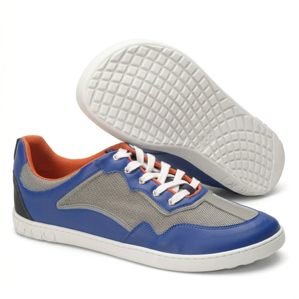 The QOPA Blue sneakers from ZAQQ feature a breathable blue-grey mesh design, orange lining and white laces. One shoe is presented upright and the other on its side, highlighting a textured sole.