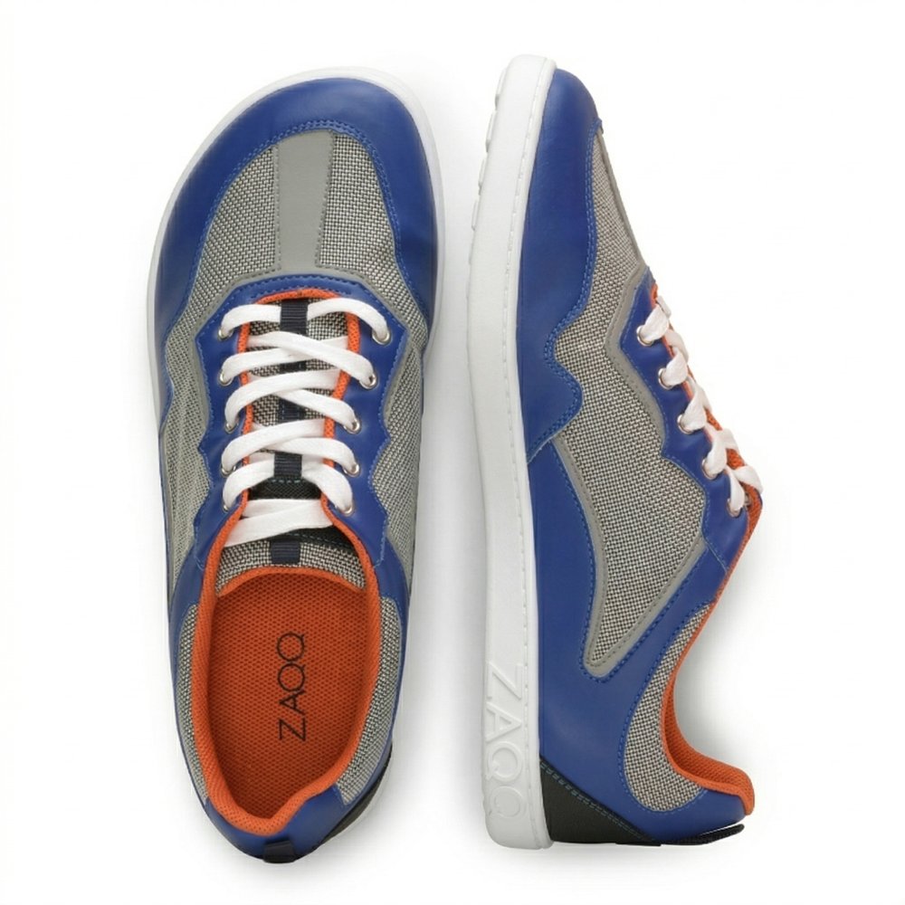 Introducing the QOPA Blue sneakers from ZAQQ, which are equipped with a wide toe area and made of breathable mesh fabric. The side view of the left sneaker highlights a textured white sole for better grip, while the top view of the right sneaker shows the lacing and the ZAQQ-Branding clearly stands out.