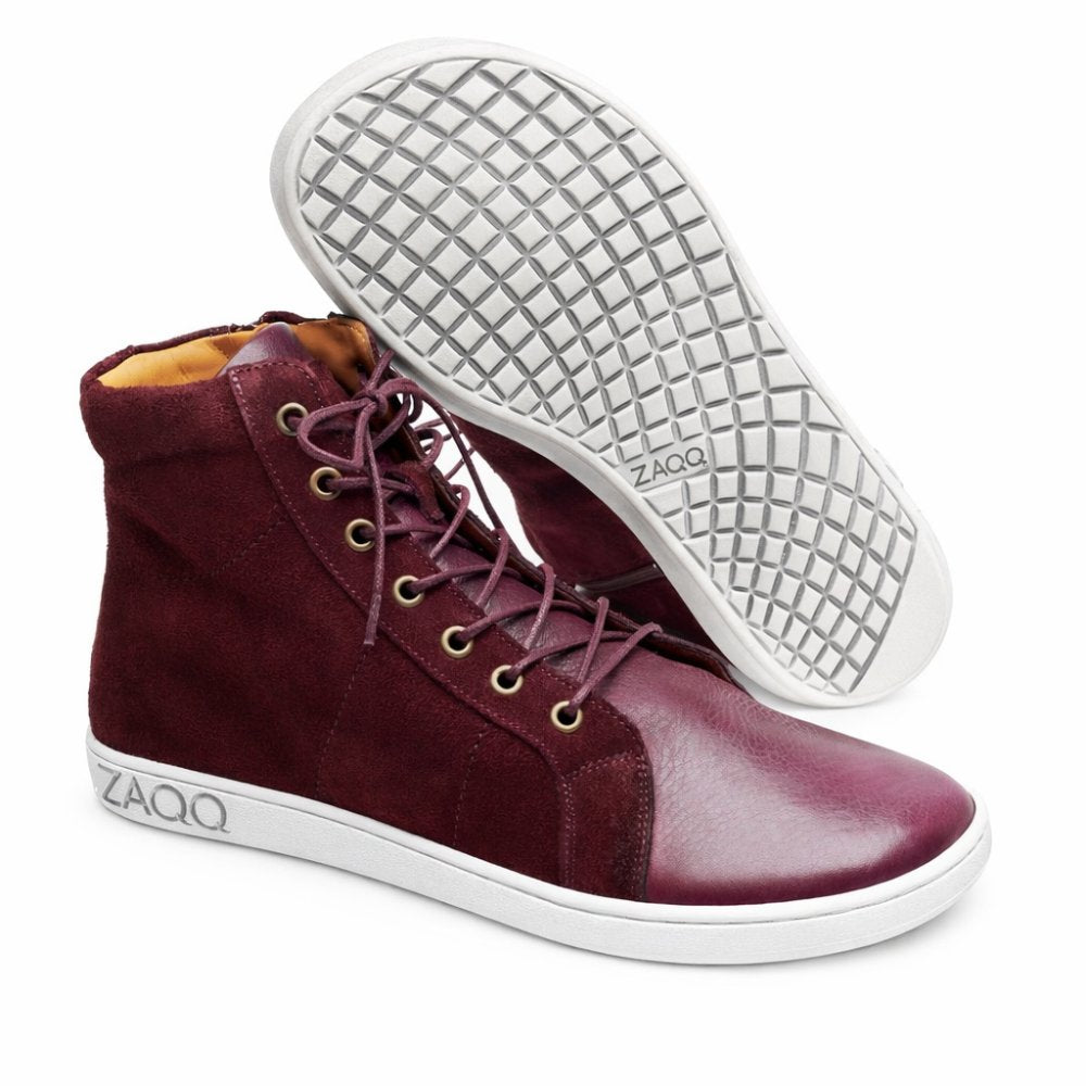 A pair of QORE High Mazarine sneakers in maroon, made by ZAQQ made from a combination of suede and smooth leather. These mid-cut sneakers feature a textured sole with the brand clearly engraved ZAQQ, Laces and a modern, casual design.