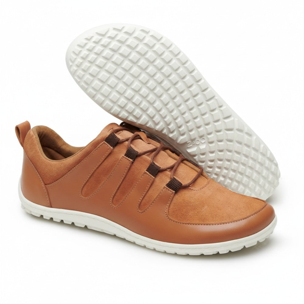The SHOQQ cognac sneakers from ZAQQ are characterized by a sophisticated design made of light brown leather, highlighted by brown elastic straps. The lack of visible laces ensures maximum flexibility and style. Their unique white rubber lattice sole offers exceptional comfort on the go.