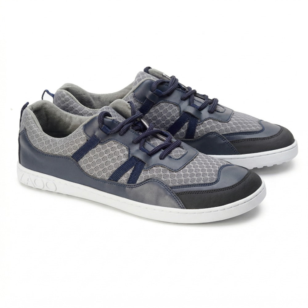 We present the stylish SQATE Gray sneakers from ZAQQ: a pair of casual shoes with a gray honeycomb pattern on the top and navy blue accents. These beauties feature white soles, navy laces and a textured design on the sides, making them perfect for any casual outing.