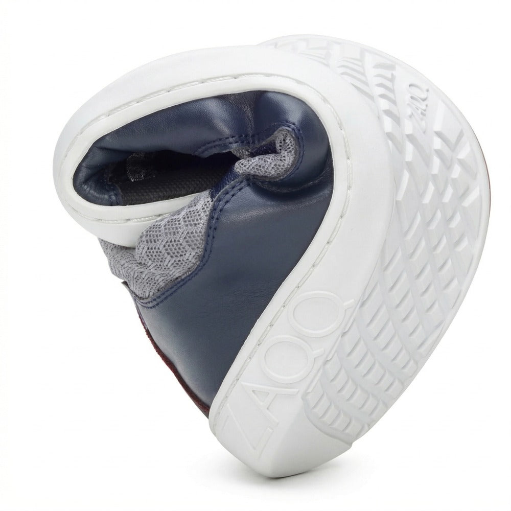 The ZAQQ SQATE gray women's sneakers, a barefoot shoe, are remarkably flexible and can be easily bent in half. With its stylish navy and white design and textured sole, it's ideal for everyday wear and features the brand name prominently displayed on the heel.