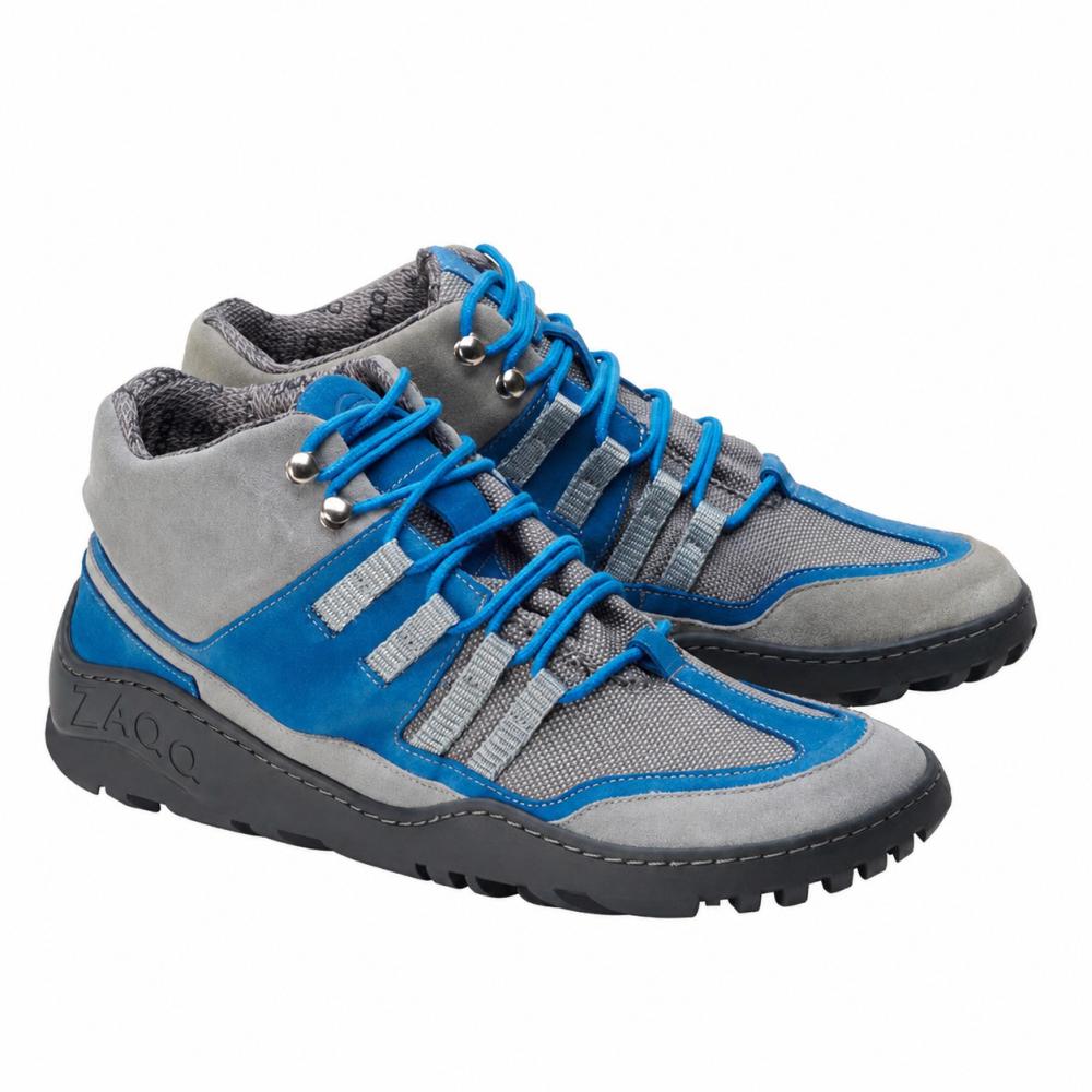 Wir präsentieren die SQOUT Grey Blue Waterproof-Schuhe von ZAQQ, die ein modernes Design mit blauen Schnürsenkeln, grauem Mesh-Gewebe und auffälligen blauen Akzenten auf einer robusten schwarzen Sohle präsentieren. Ihr sportliches Aussehen wird durch eine atmungsaktive Qualität ergänzt, was sie ideal für Outdoor-Abenteuer macht.
