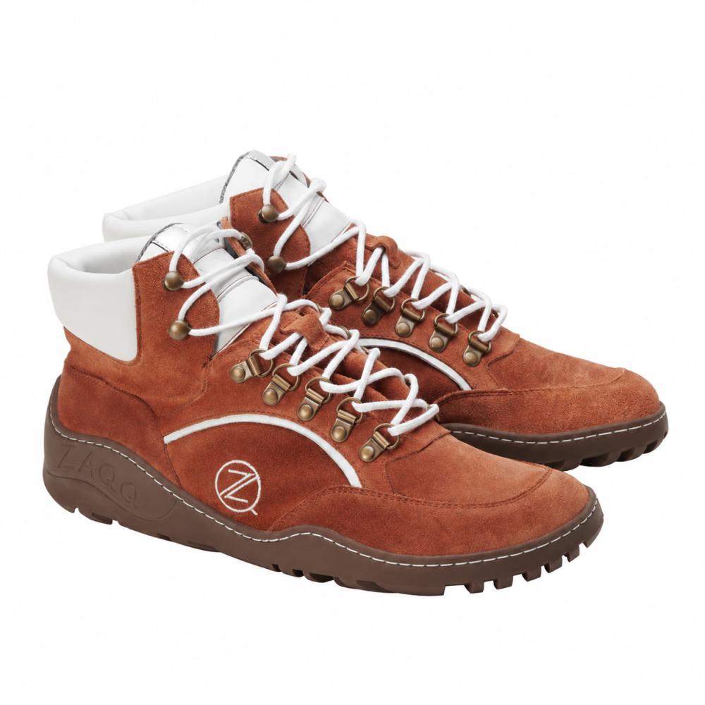 A pair of waterproof hiking boots TERRAQ Cognac by ZAQQ with a suede finish in warm brown with white laces and accents around the ankle. These barefoot shoes feature sturdy brown soles and metallic eyelets, making them perfect for outdoor adventures.