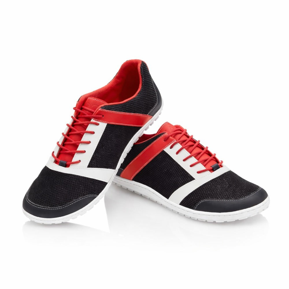 Ein Paar schicke ZARQA Black-Sneaker von ZAQQ bestechen durch ein schwarzes Mesh-Obermaterial mit weißen und roten Akzenten, ergänzt durch rote Schnürsenkel und eine elegante weiße Sohle – alles vor einem makellos weißen Hintergrund.